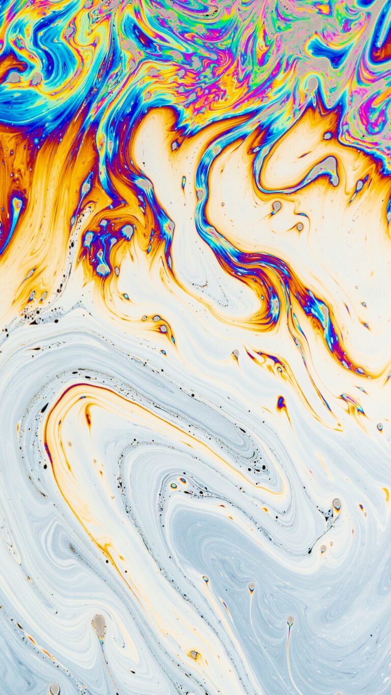 Macro photography of swirling liquid textures featuring vibrant rainbow colors including yellow, blue, cyan, and red in a fluid pattern.