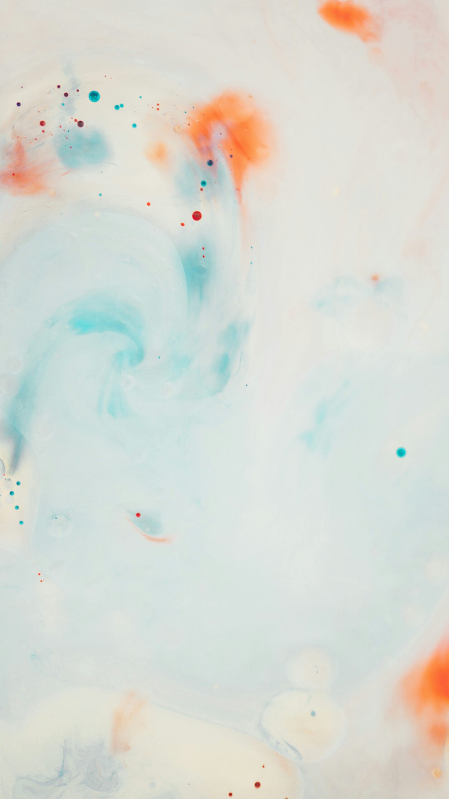 Abstract watercolor texture featuring swirling pale blue and soft orange paint on a white background, with tiny scattered droplets.