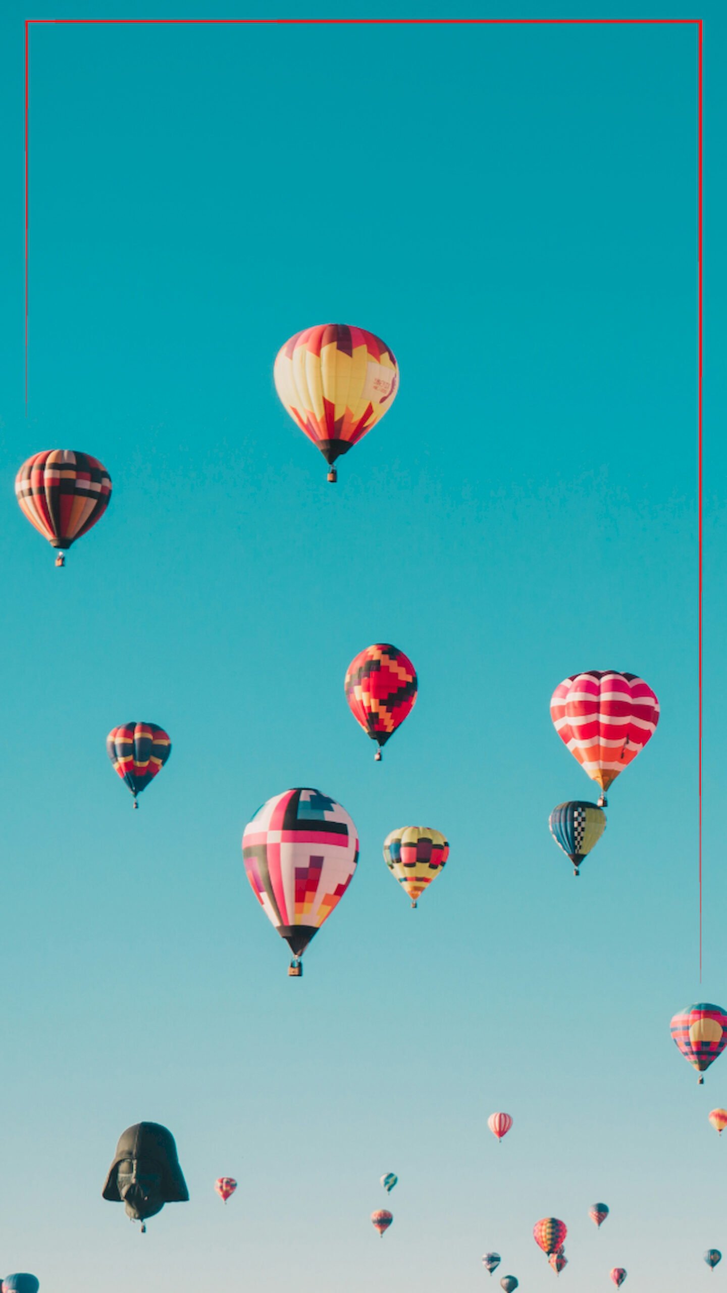 Low angle view of many colorful hot air balloons flying in a clear teal blue sky, vertical 4K phone wallpaper