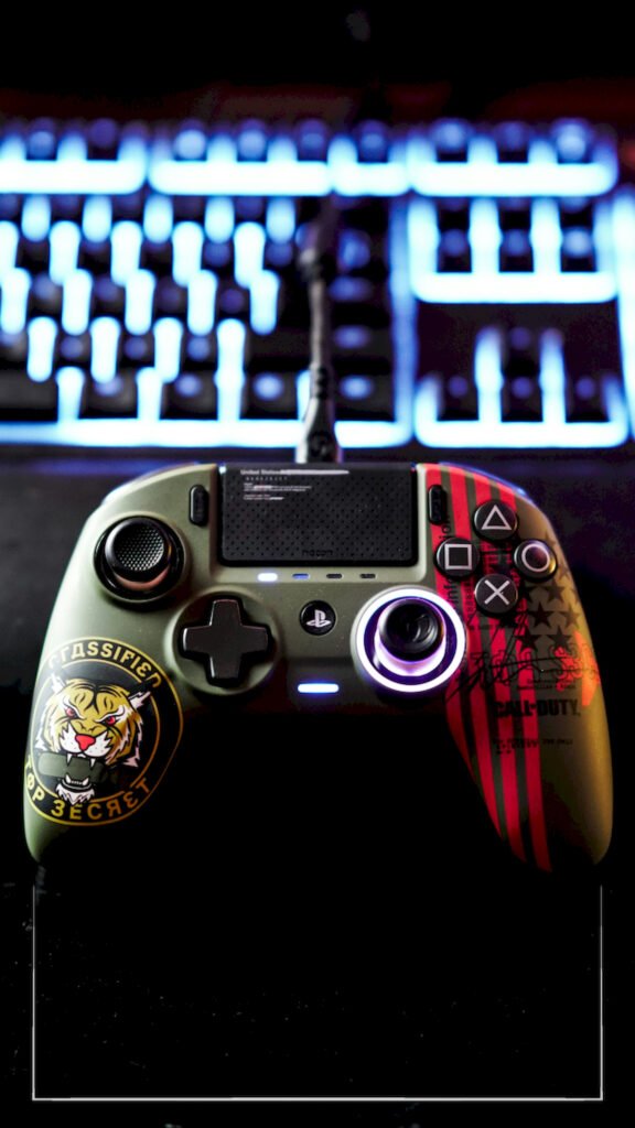 Close-up of a custom green military-style gaming controller featuring a tiger sticker, sitting in front of a blurred mechanical keyboard with blue RGB lighting.