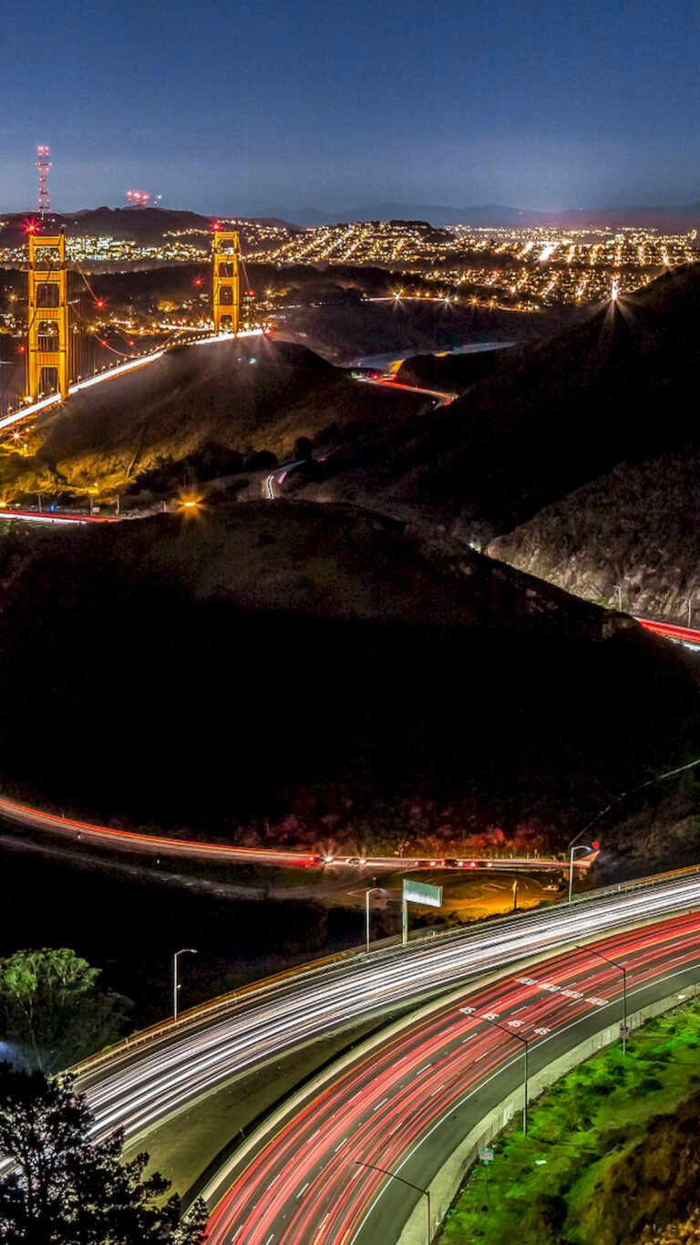 Vertical night photography of Golden Gate Bridge in San Francisco with long exposure car light trails, 4K phone wallpaper