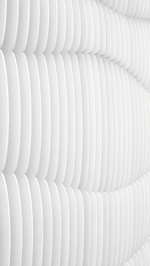 Abstract wallpaper featuring repeating vertical white curved slats or lines with soft grey shadows, creating a clean 3D wave pattern.