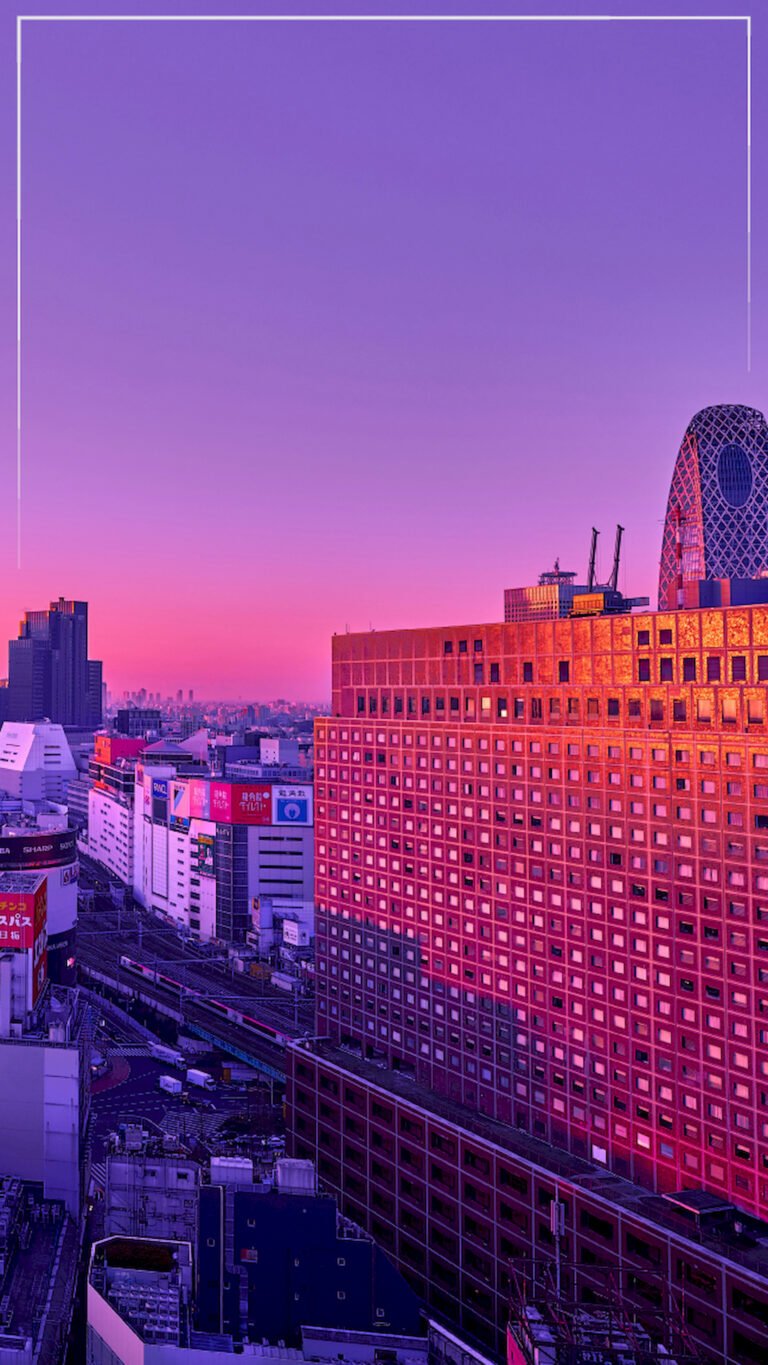 Vertical view of Shinjuku Tokyo skyline with Mode Gakuen Cocoon Tower under a pink and purple sunset, 4K phone wallpaper.